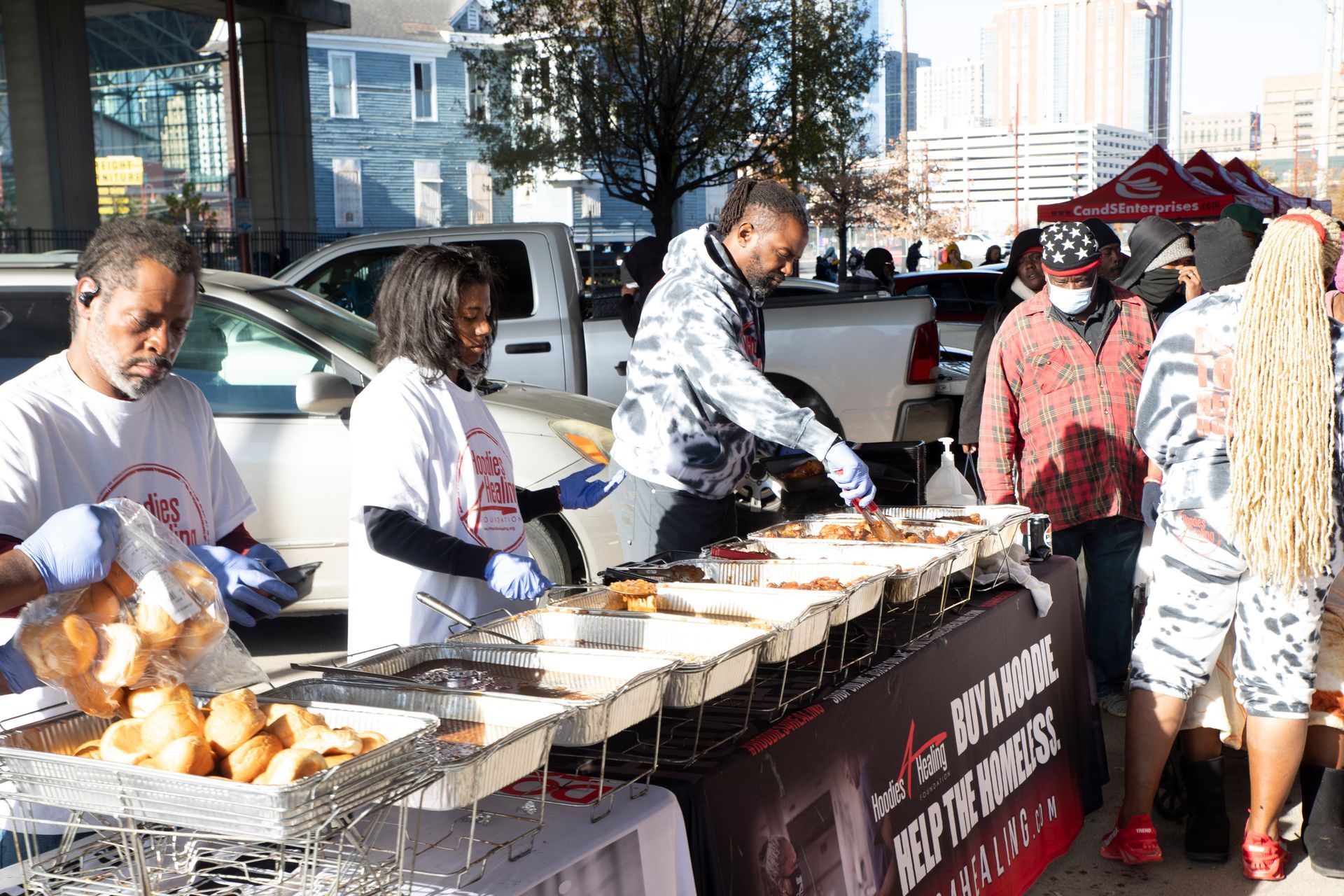 A group of people are standing around a table serving food.