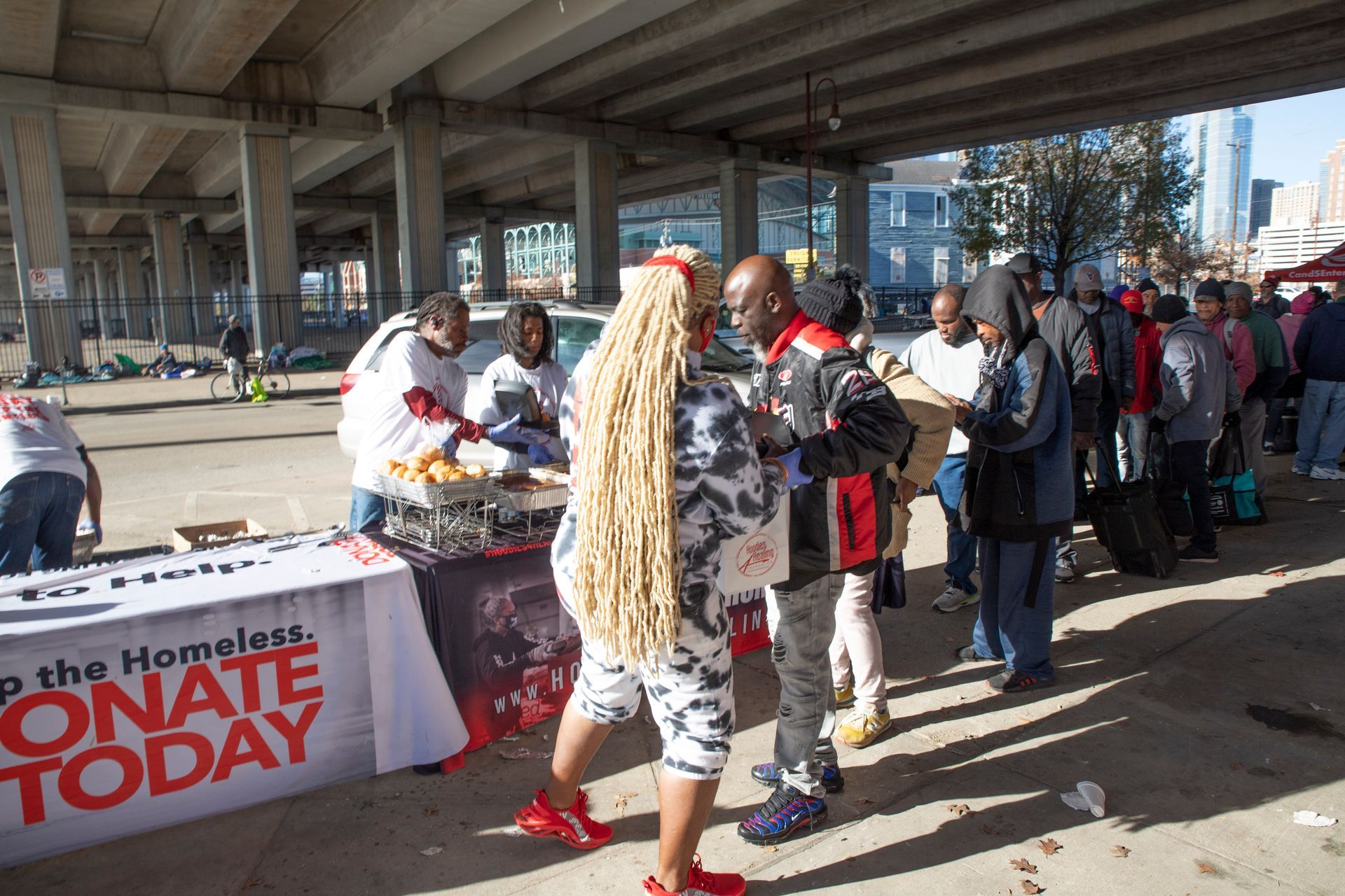 A group of people standing around a table that says donate today