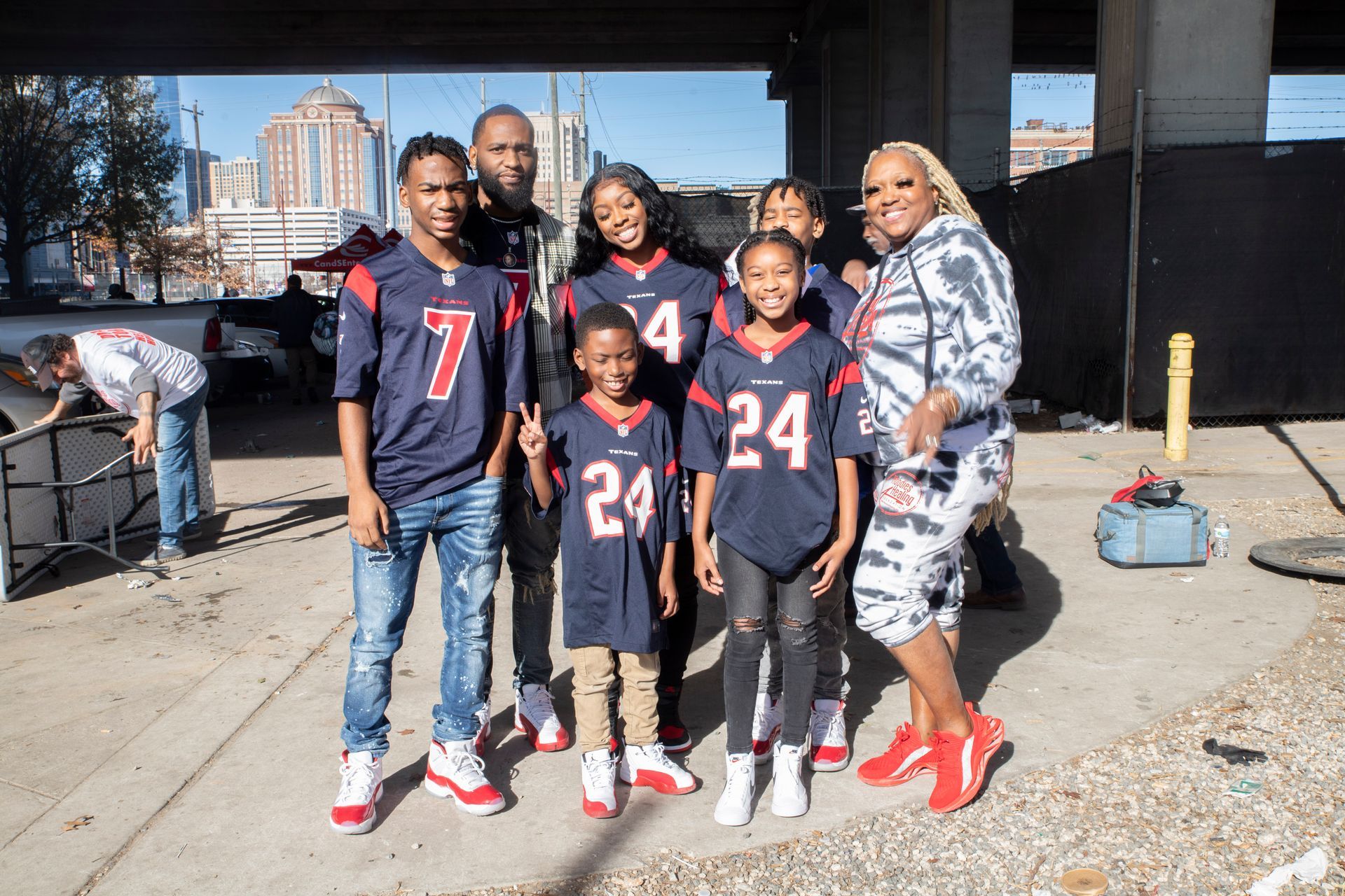 A group of people standing next to each other wearing football jerseys.