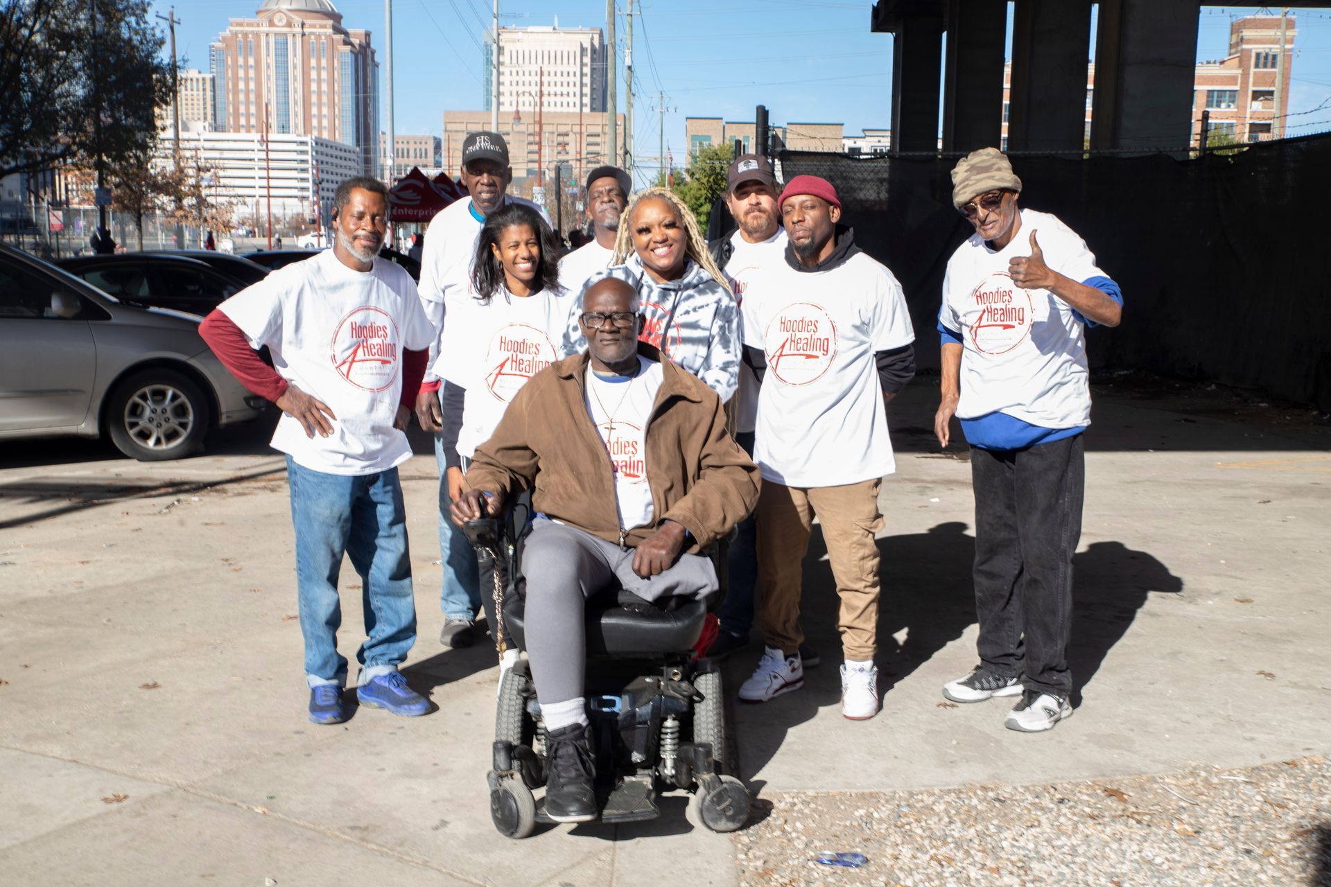 A group of people posing for a picture with one man in a wheelchair