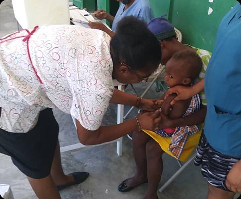A group of people are posing for a picture while holding a large check.