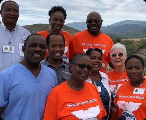 A woman wearing a crown is posing for a picture with two men.