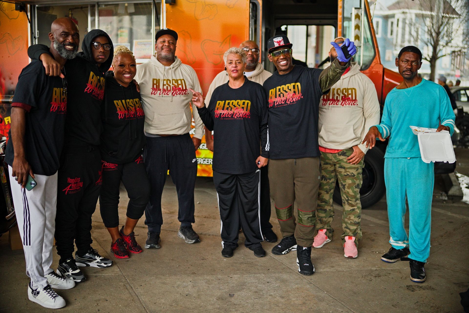 A man wearing a black shirt that says join us to make a difference is preparing food.