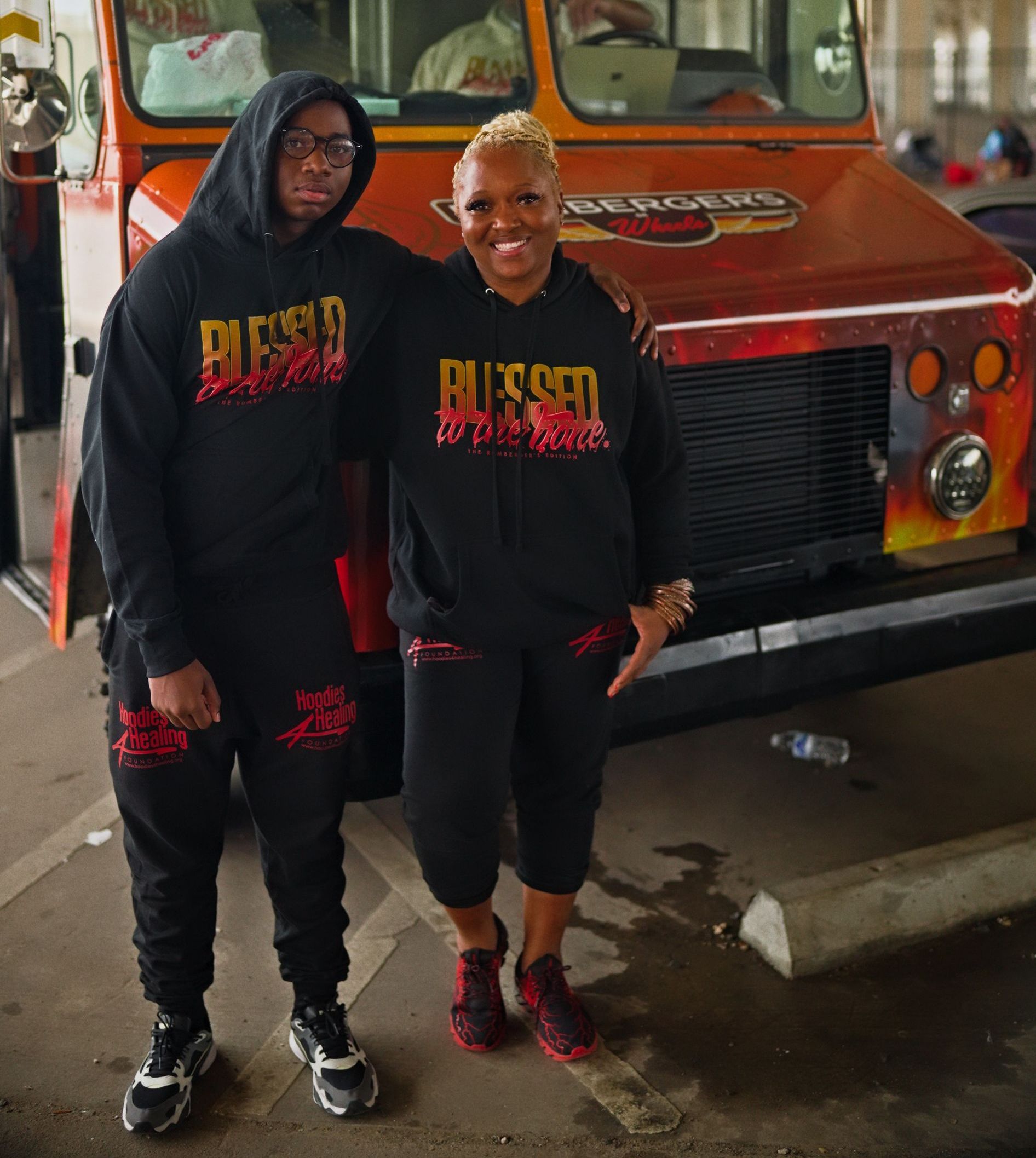 A woman in a red hoodie and red shorts is standing in a parking lot.
