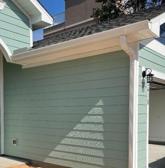 A green house with a white gutter