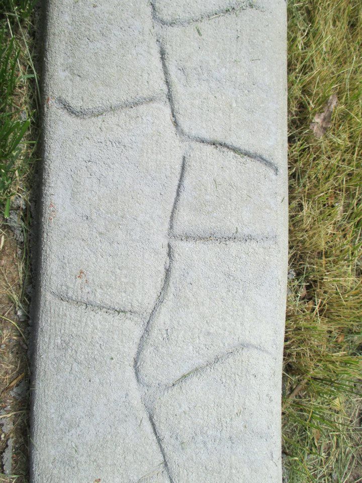 Gray concrete border with textured surface and faux stone pattern.
