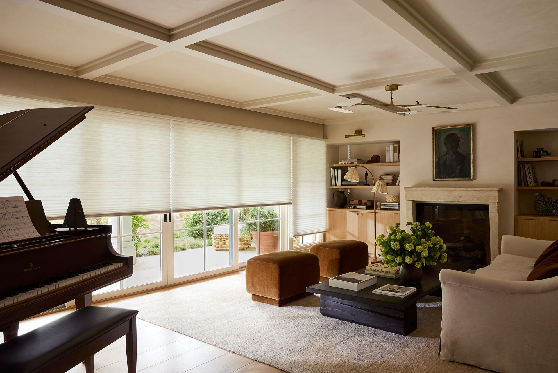 Living room with piano, seating area, and sliding glass doors with light filtering shades.