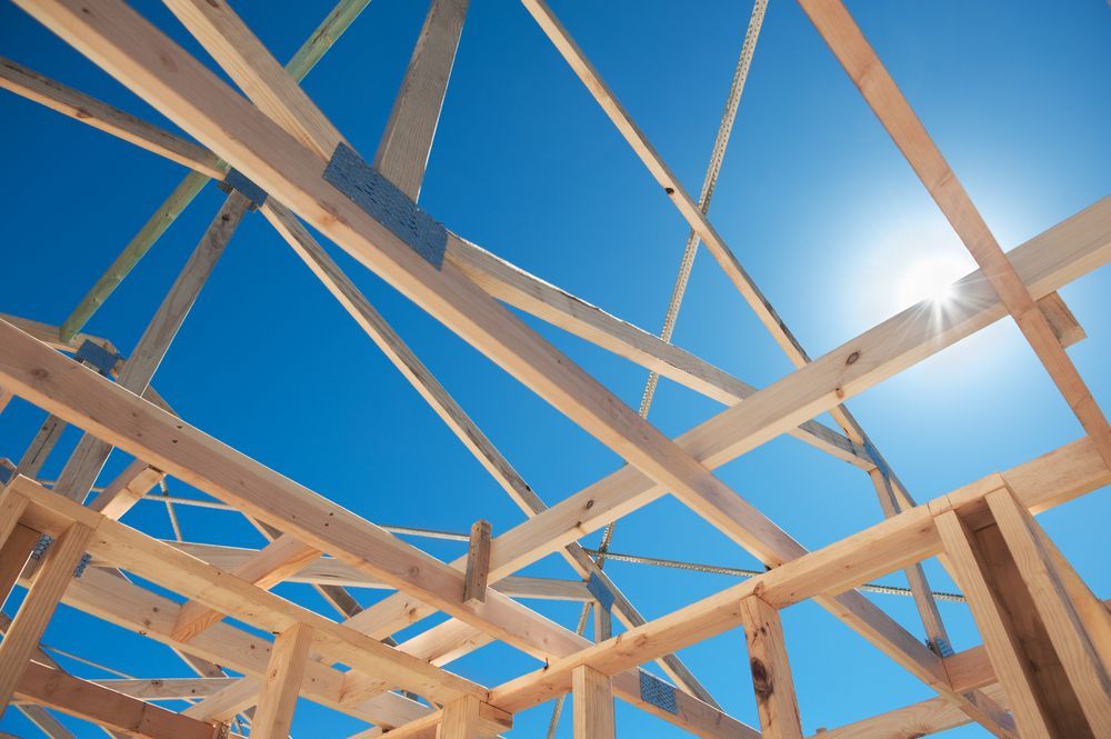 Wooden House Frame Under Bright Blue Sky