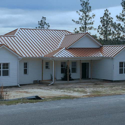 a white house with a brown roof is under construction