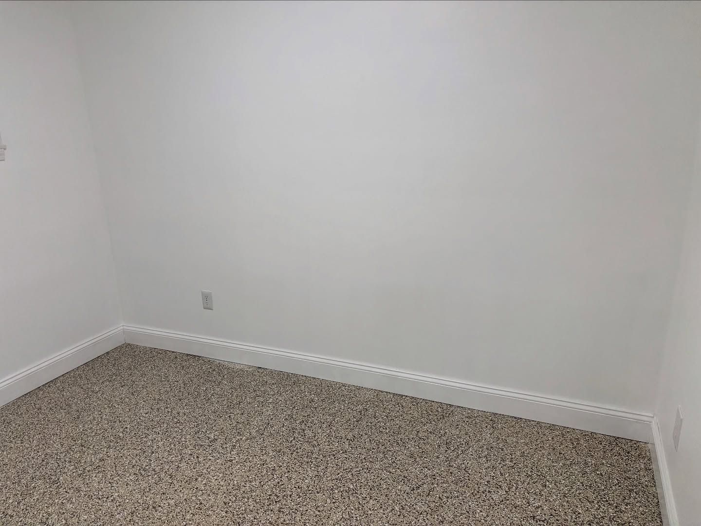 Empty room with off-white walls, carpeted floor, and baseboards.