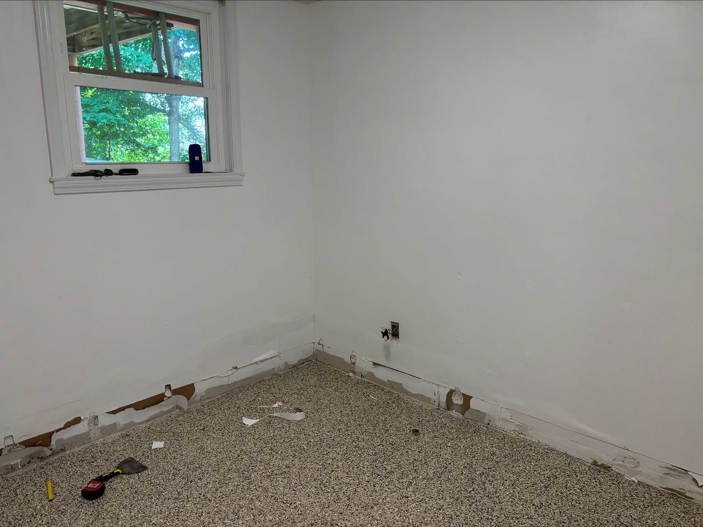 Room with exposed subfloor, white walls, small window, and plumbing fixtures.