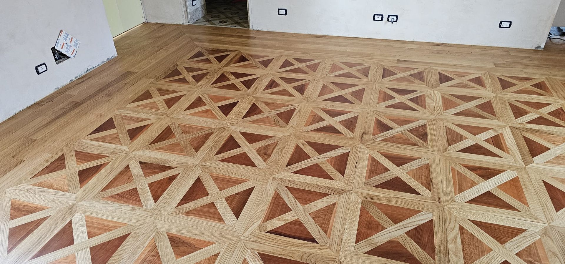 Pavimento in parquet con motivo geometrico.