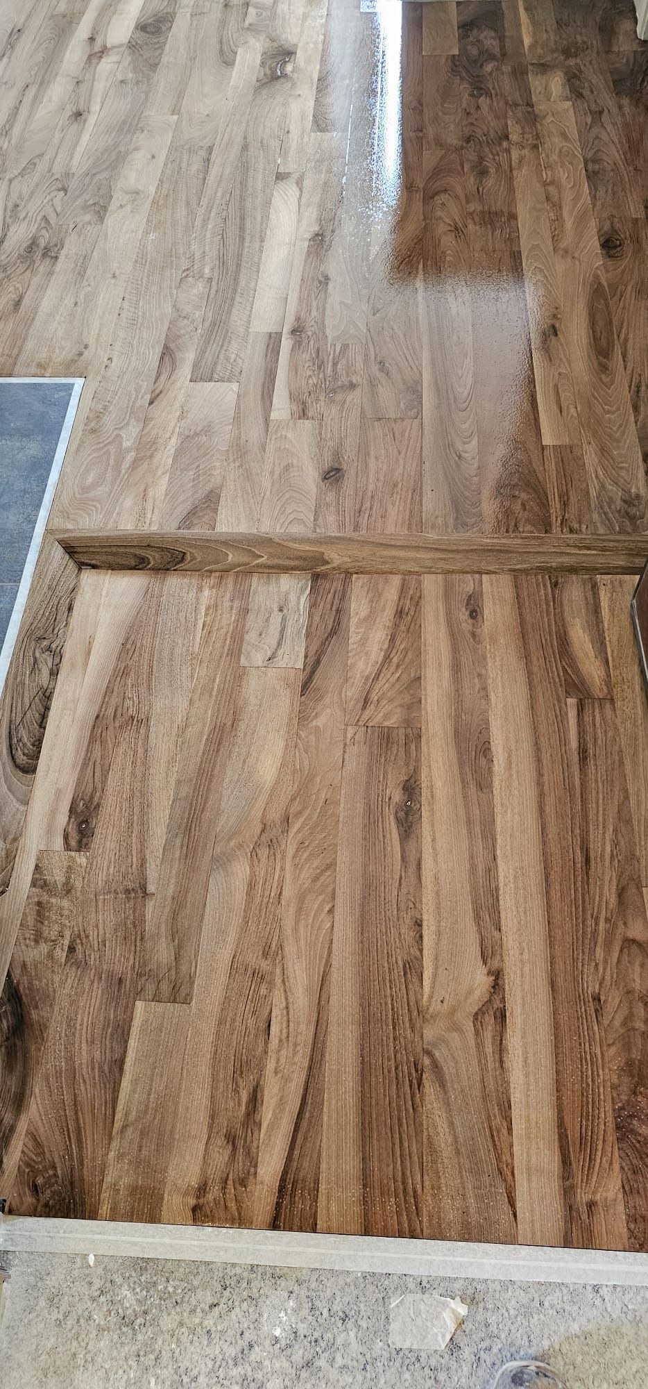 Pavimento in legno con finitura marrone e cornice in legno.