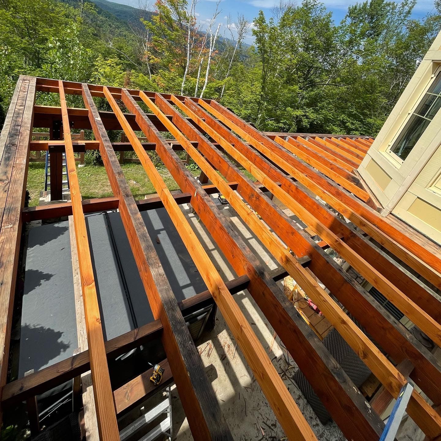Une terrasse en bois est en cours de construction sur le toit d'une maison.