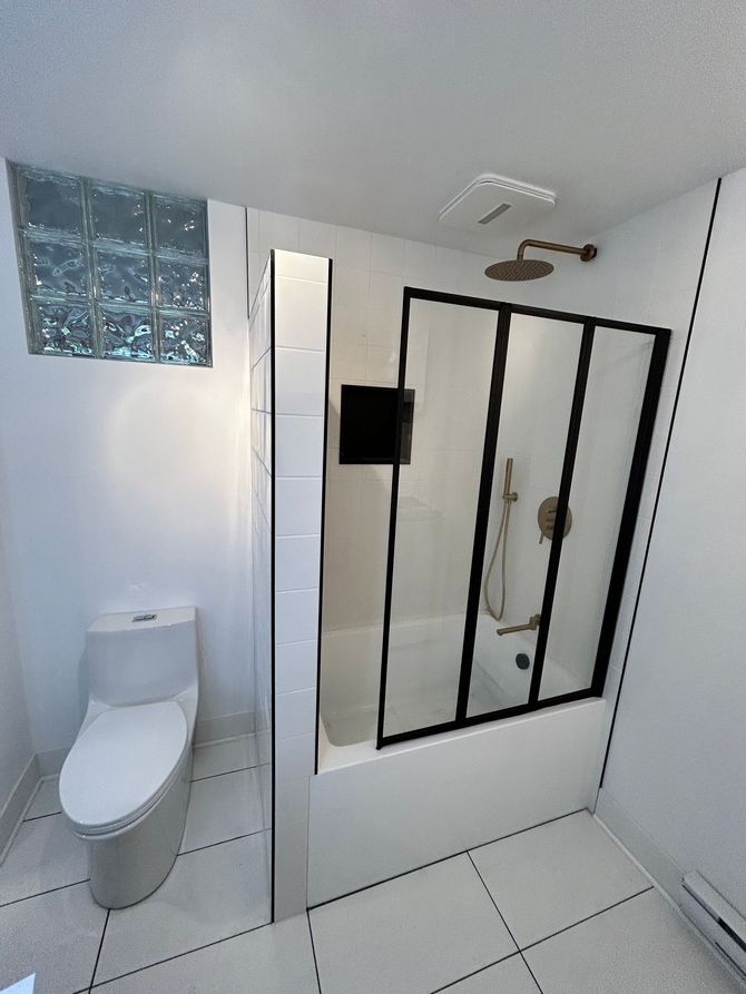 Une salle de bain avec toilettes, une douche et une baignoire