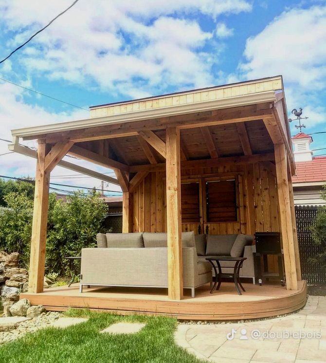 Un gazebo en bois avec un canapé et une table en dessous