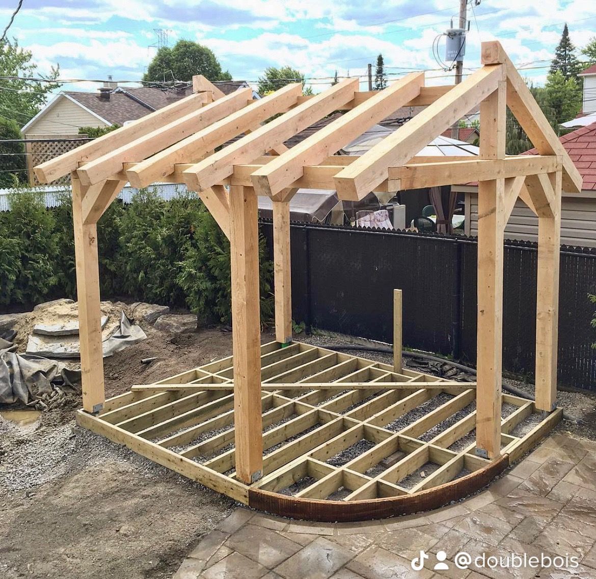 Une structure en bois est en cours de construction dans une arrière-cour.