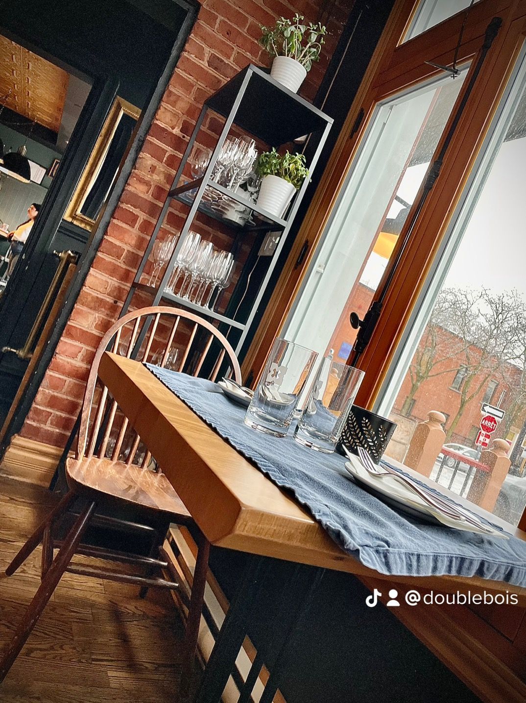 Un restaurant avec une table et des chaises devant une fenêtre.