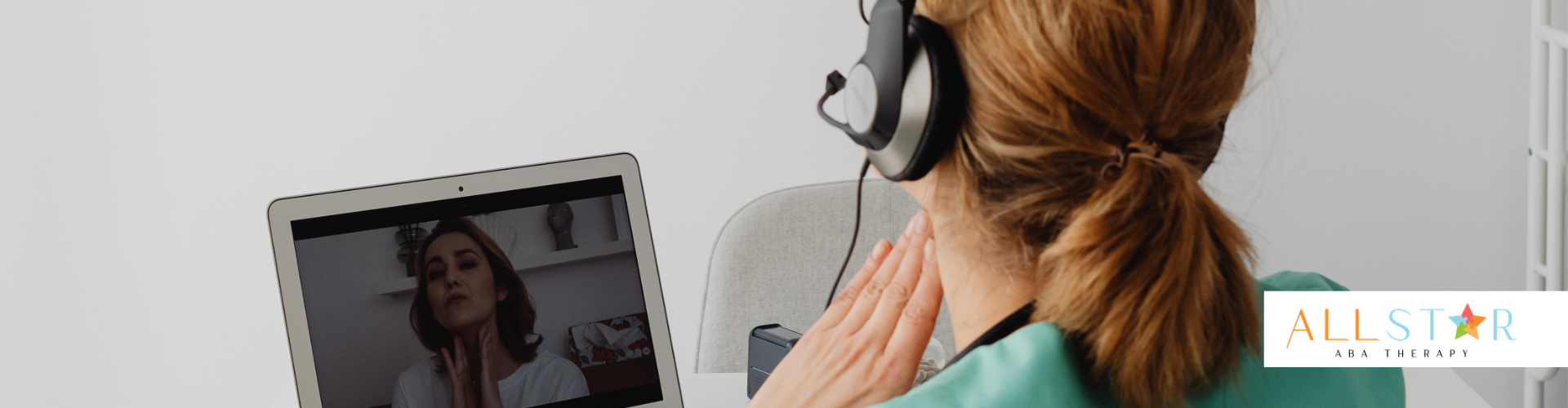 Person with headset and laptop in video call.