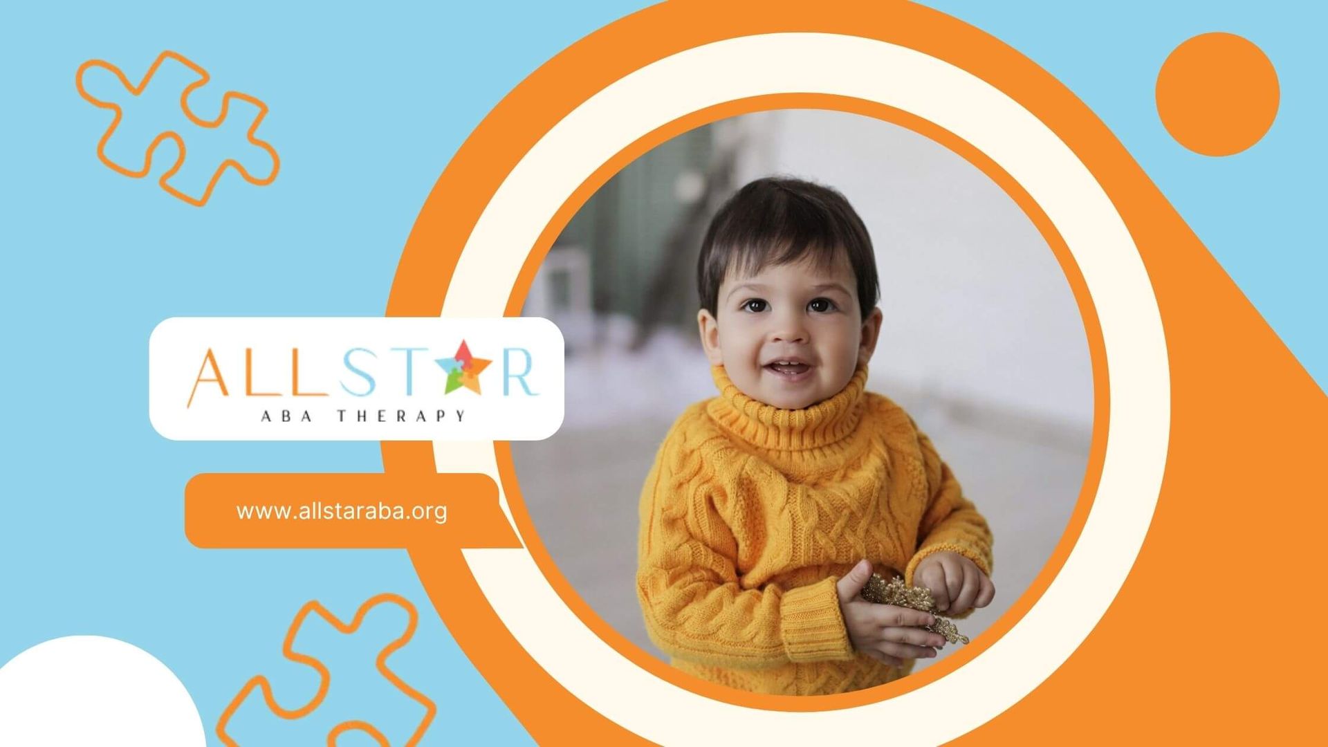 An autistic toddler is wearing a yellow sweater and smiling in ABA therapy.