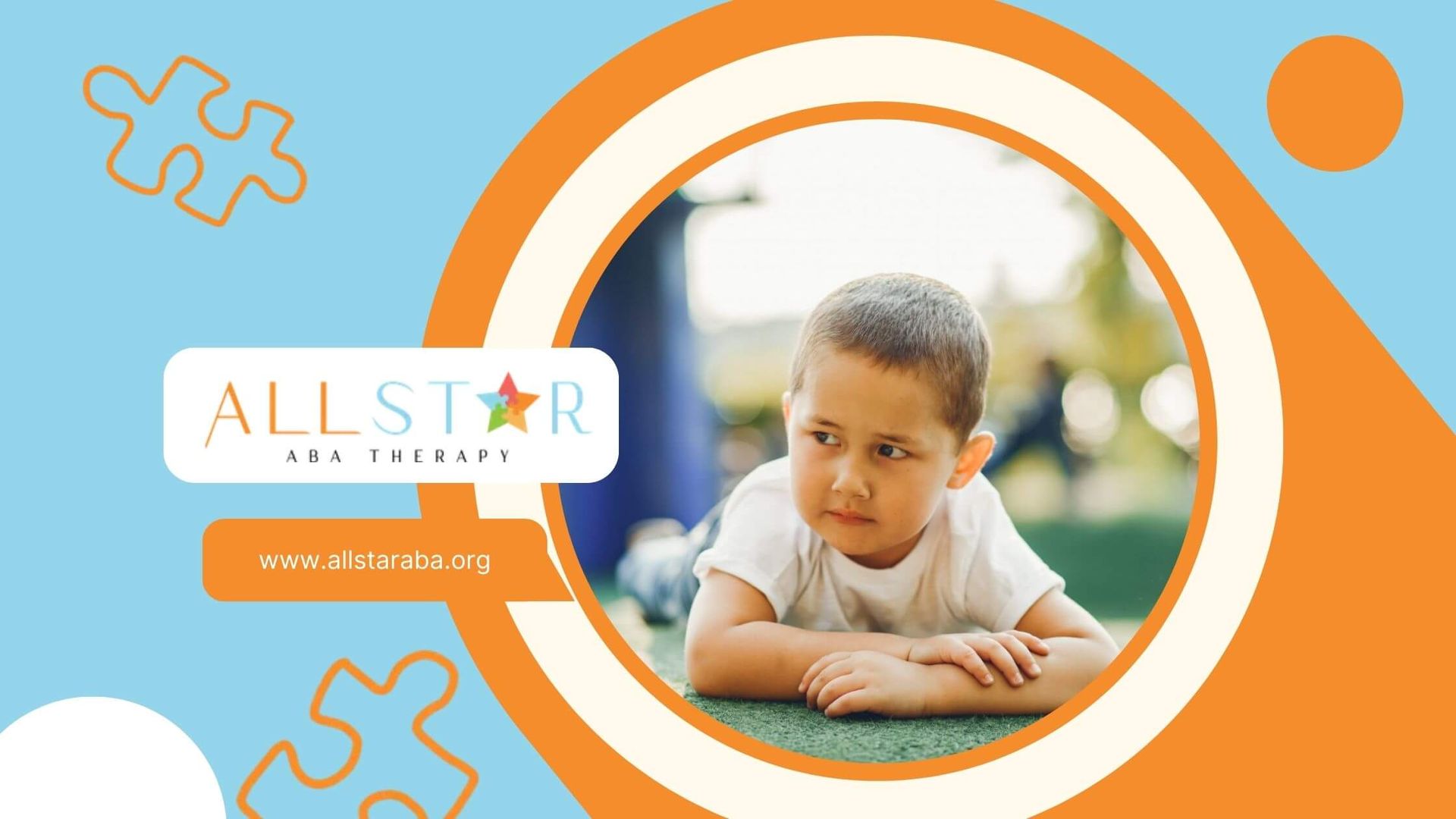 Young boy with autism lying on grass looking upset or withdrawn outdoors.