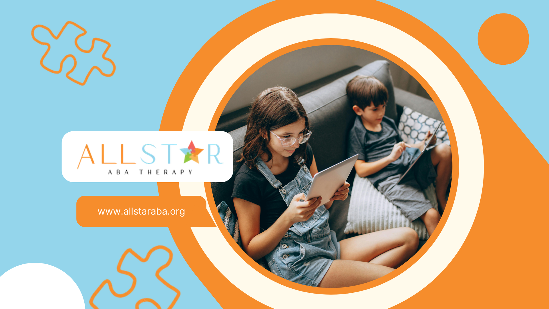 A girl and a boy are sitting on a couch looking at a tablet.
