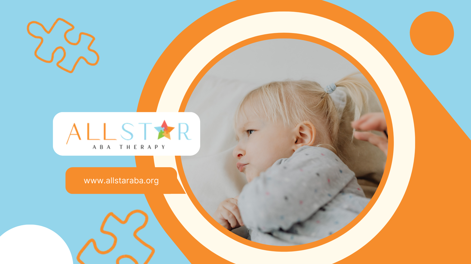 Blonde baby lying down, with person's hand holding a hair tie.