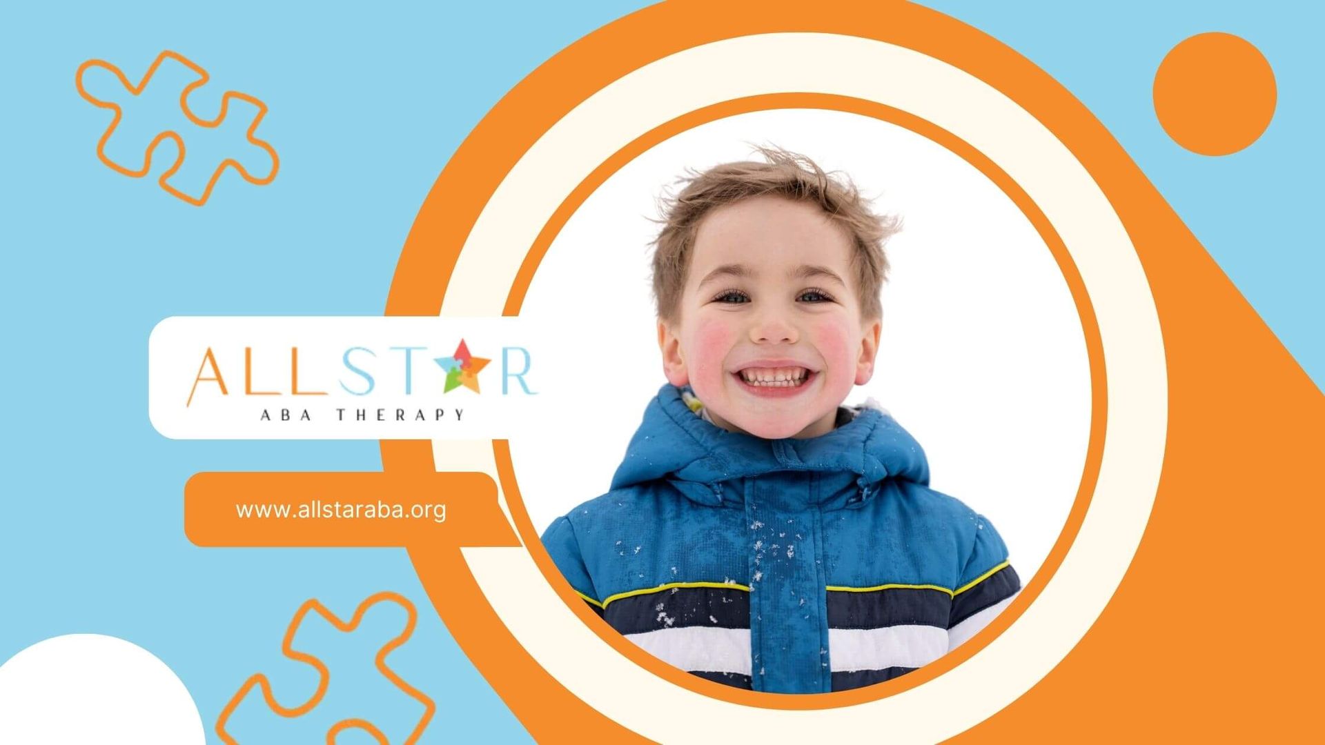 Smiling young boy with rosy cheeks in a blue winter jacket against white snow.