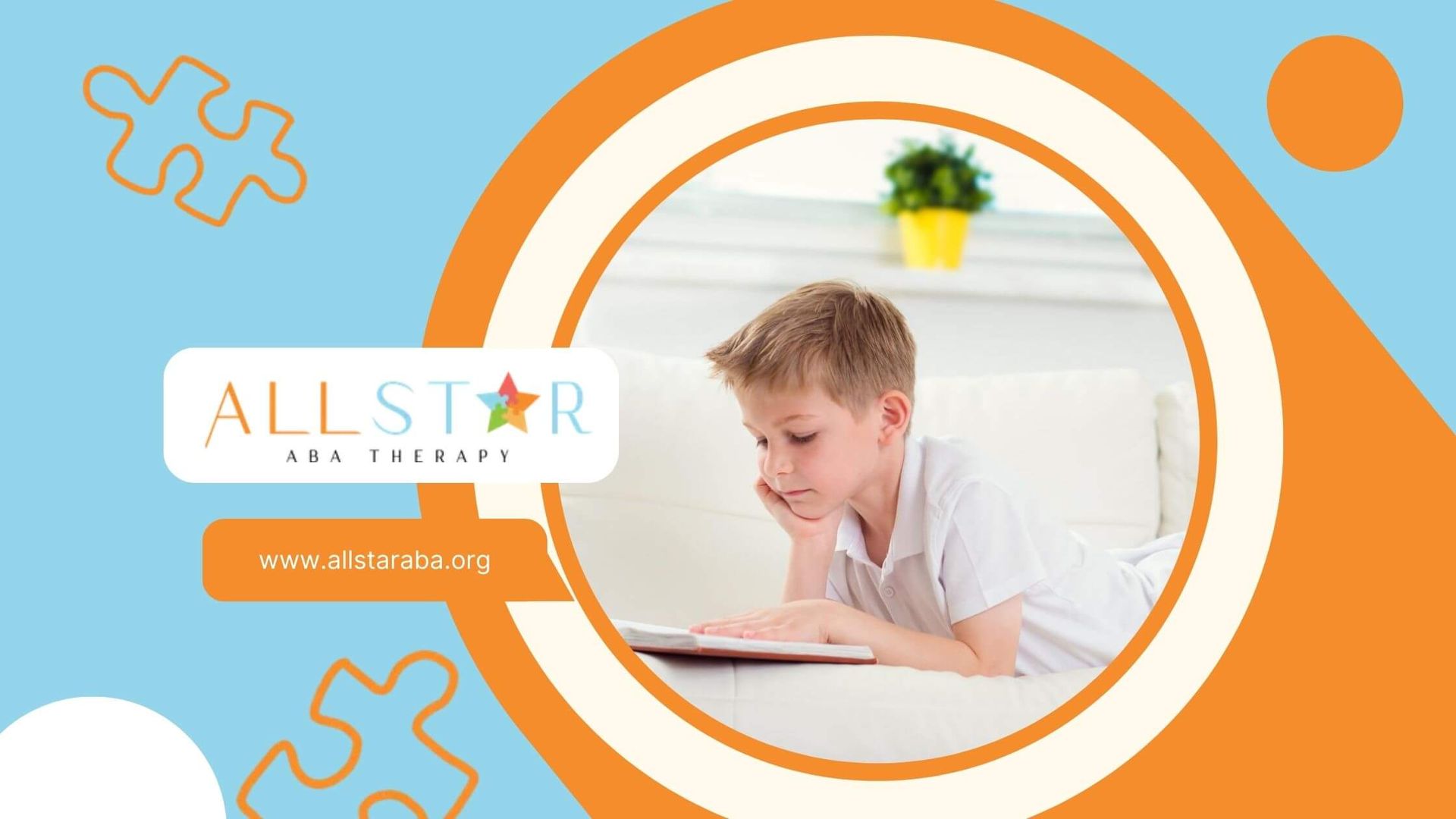Young boy with autism lying on a couch and reading a book in a bright room.