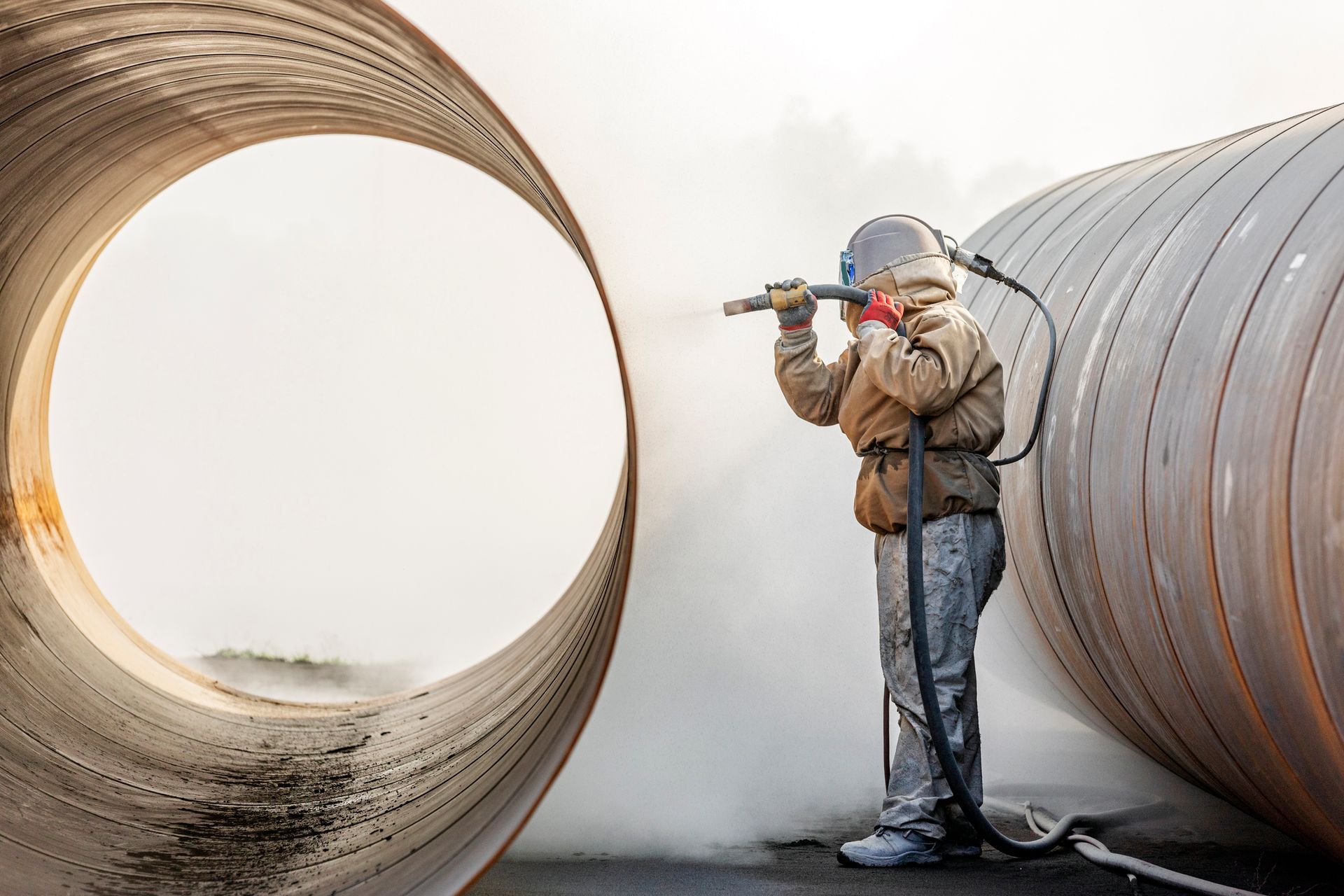 View of the manual sandblasting or abrasive blasting in the construction site. View of the manual sandblasting or abrasive blasting in the construction site.