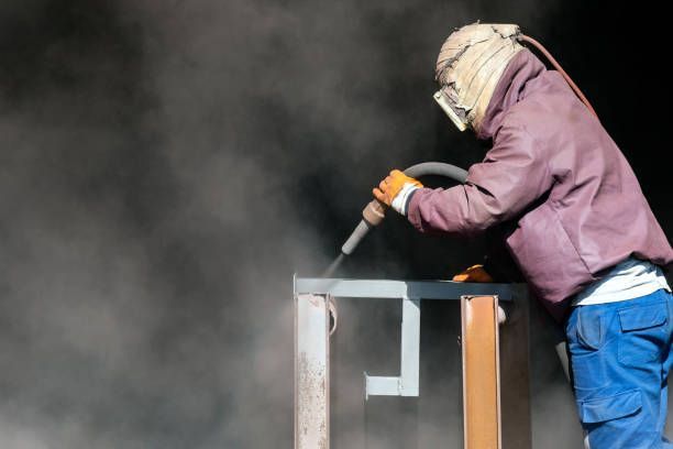 Sandblaster is sandblasting to steel material.
