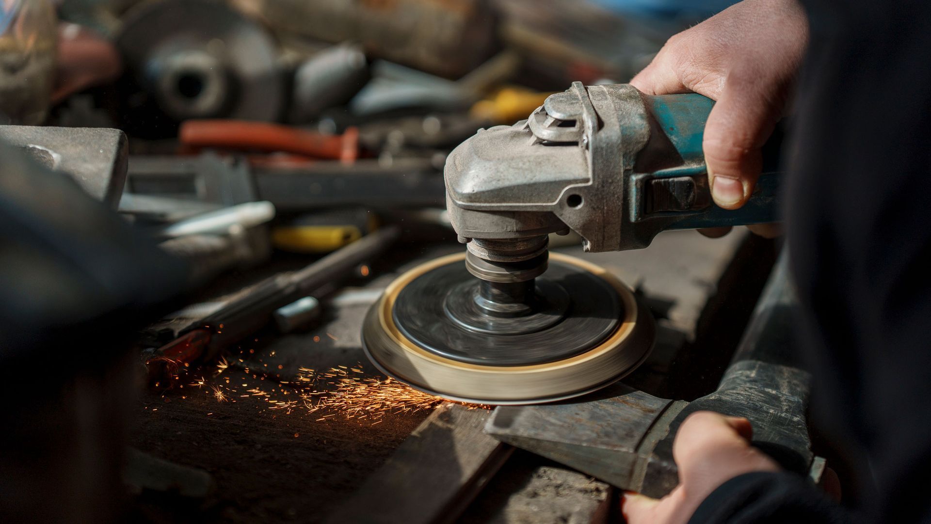 Industrial worker using angle grinder for metal stripping, sparks flying, precision abrasives, workshop safety.