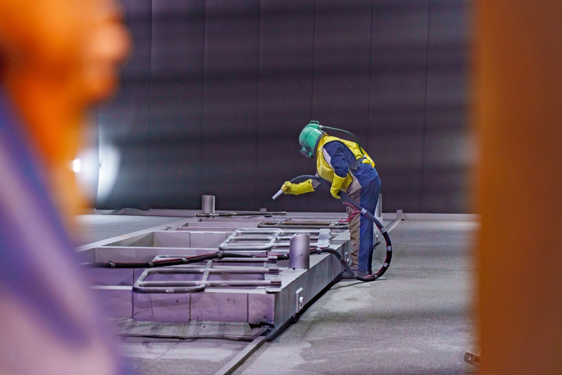 Worker in protective gear inspecting industrial equipment in a factory setting. Worker in protective gear inspecting industrial equipment in a factory setting.