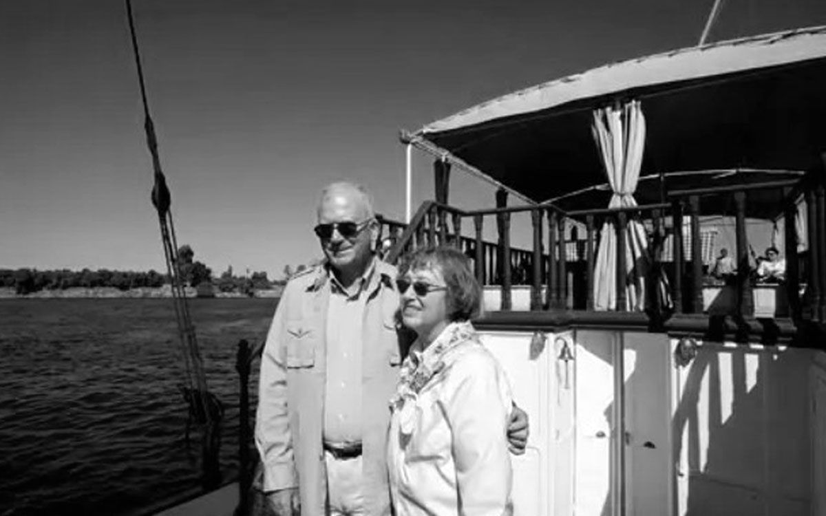 Dr. Kent Weeks and his wife pose on the original Dahabiya Kingfisher, a historic boat that dates back to 1899, on the Nile in Luxor Egypt
