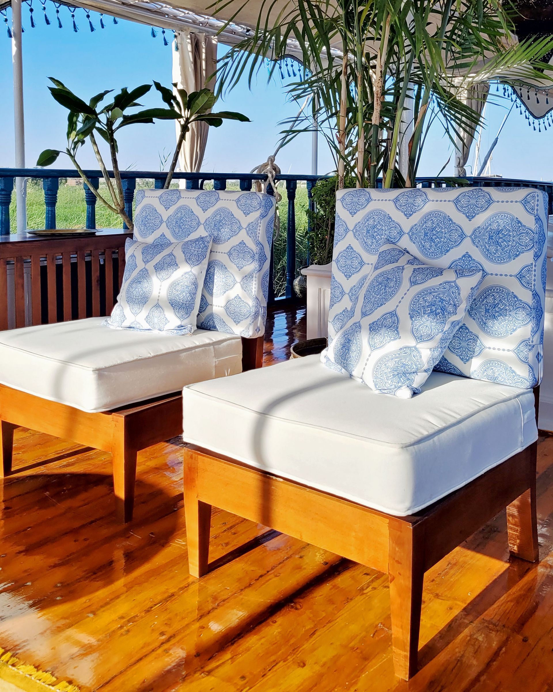 A photo of a cozy seating area on the deck of a traditional Egyptian sailing boat, the Dahabiya Kingfisher, which offers private cruises along the Nile river between Luxor and Aswan.