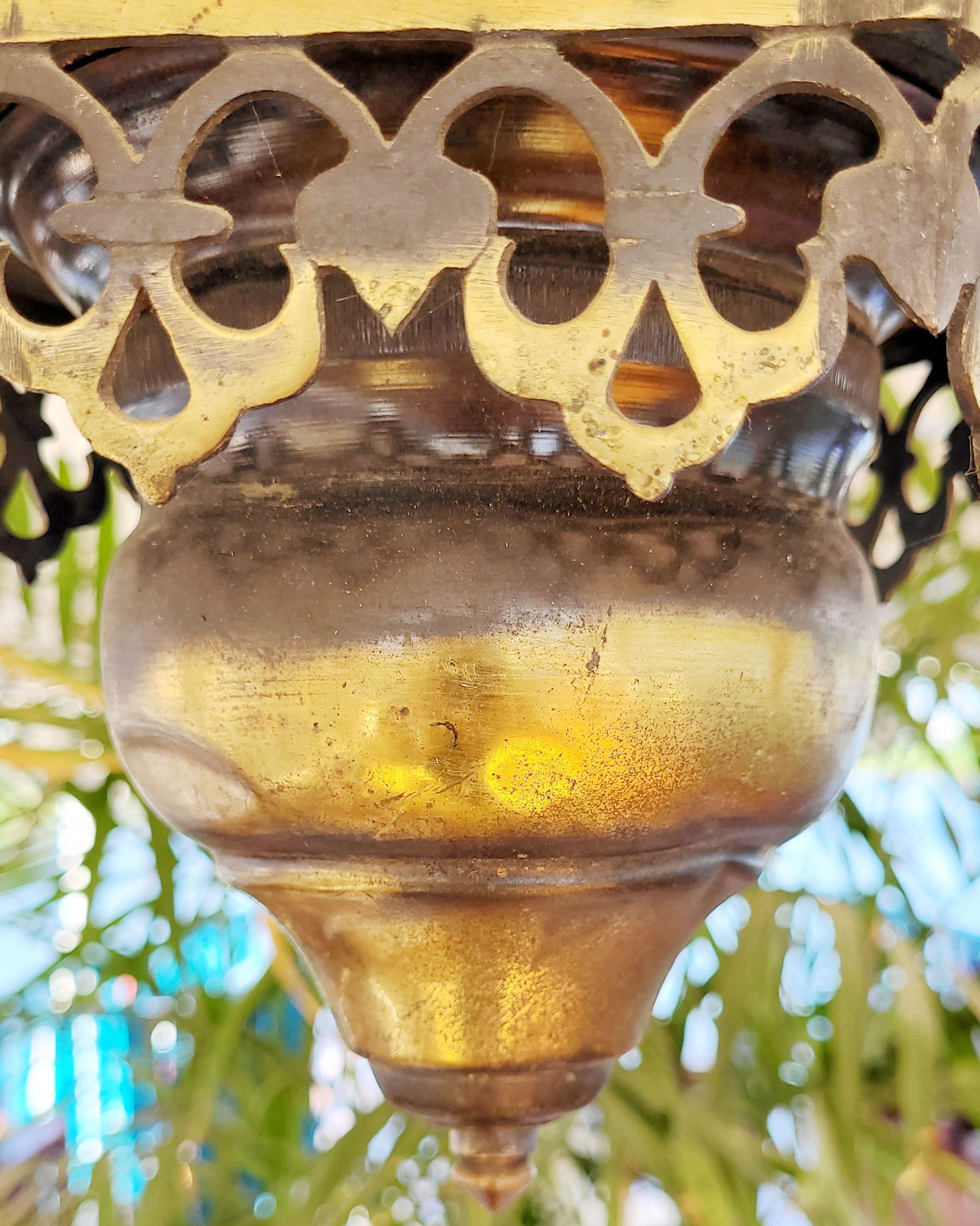 An antique copper lamp on a historic boat sailing the Nile. The boat is the Dahabiya Kingfisher, which was built in 1899 and offers private cruises between Luxor and Aswan in Egypt.