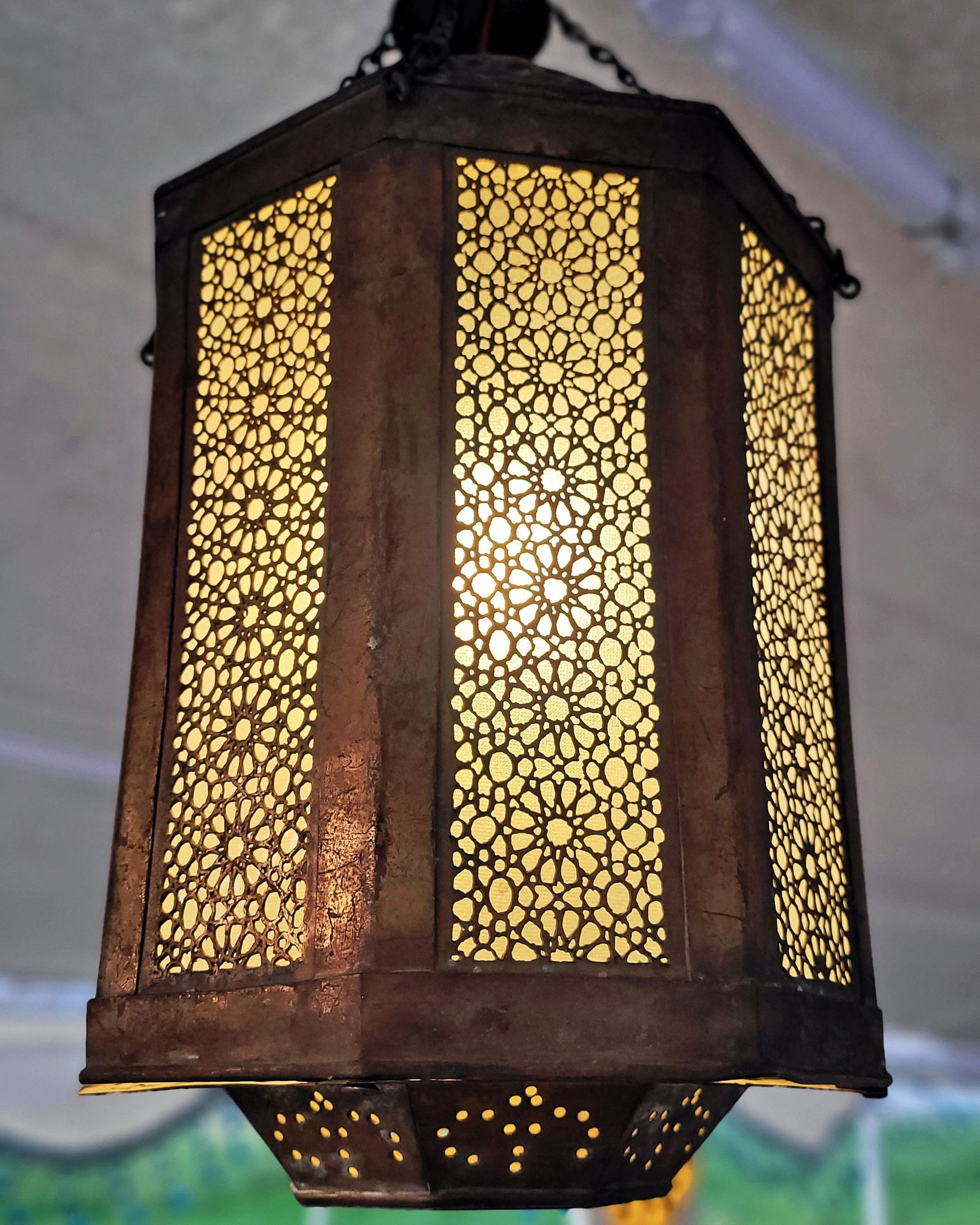 An antique copper lamp on a historic boat sailing the Nile. The boat is the Dahabiya Kingfisher, which was built in 1899 and offers private cruises between Luxor and Aswan in Egypt.