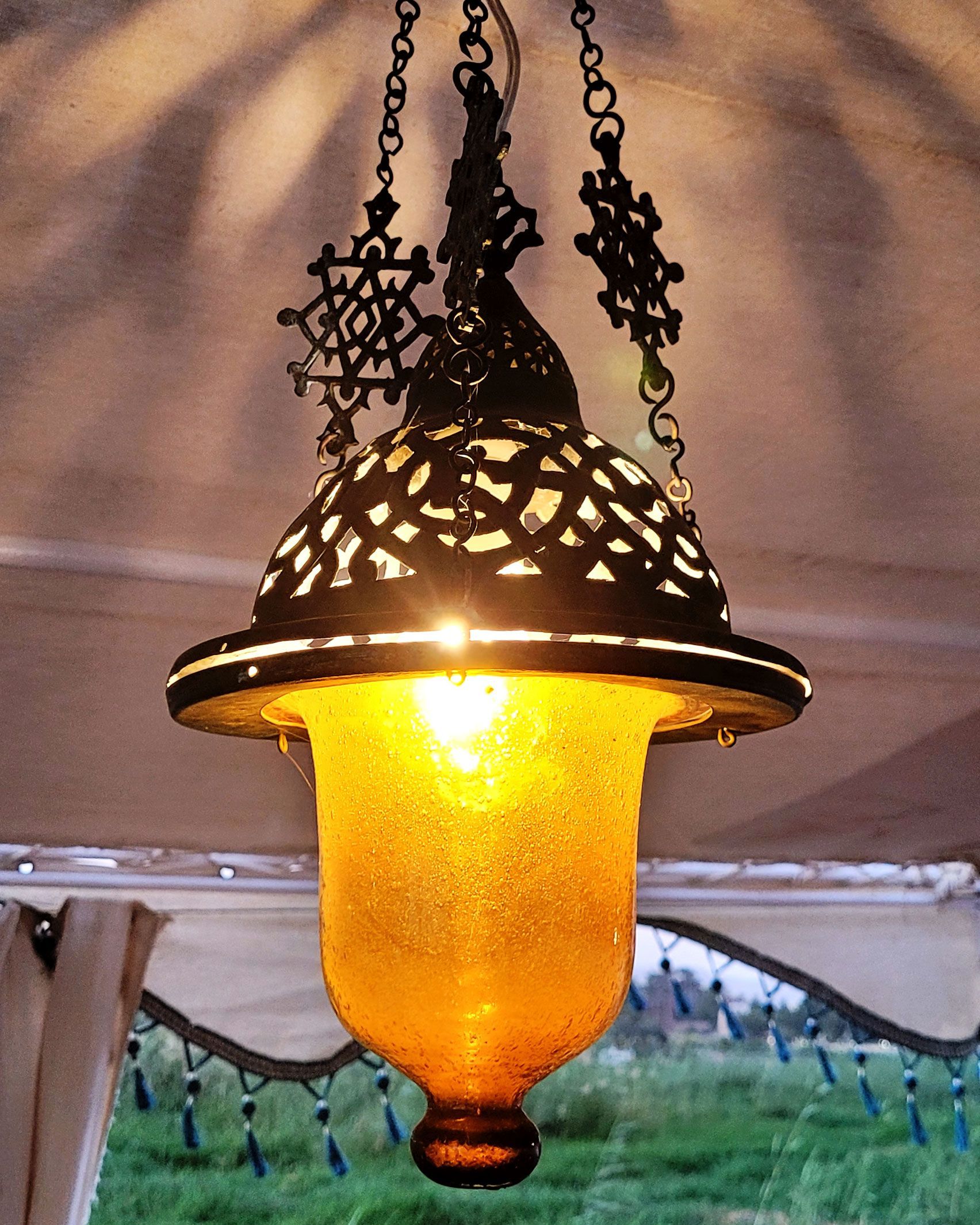 An antique copper lamp on a historic boat sailing the Nile. The boat is the Dahabiya Kingfisher, which was built in 1899 and offers private cruises between Luxor and Aswan in Egypt.