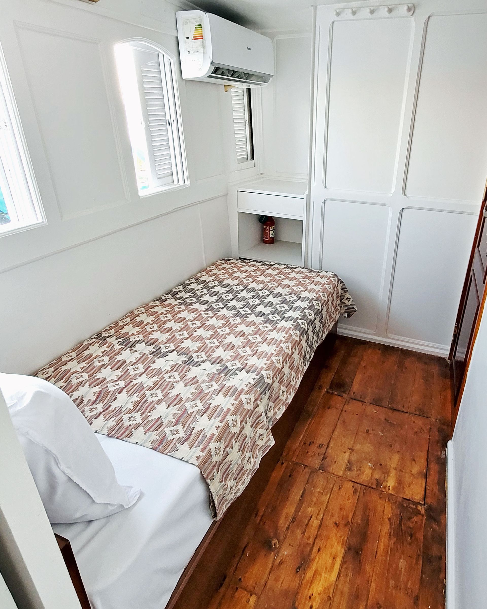 A picture of a cozy and elegant cabin/suite on the Dahabiya Kingfisher, a historic boat that offers exclusive Nile cruises between Luxor and Aswan. The Dahabiya Kingfisher is the original 1899 boat that was used by aristocrats and royalty to explore the Nile in style and comfort.