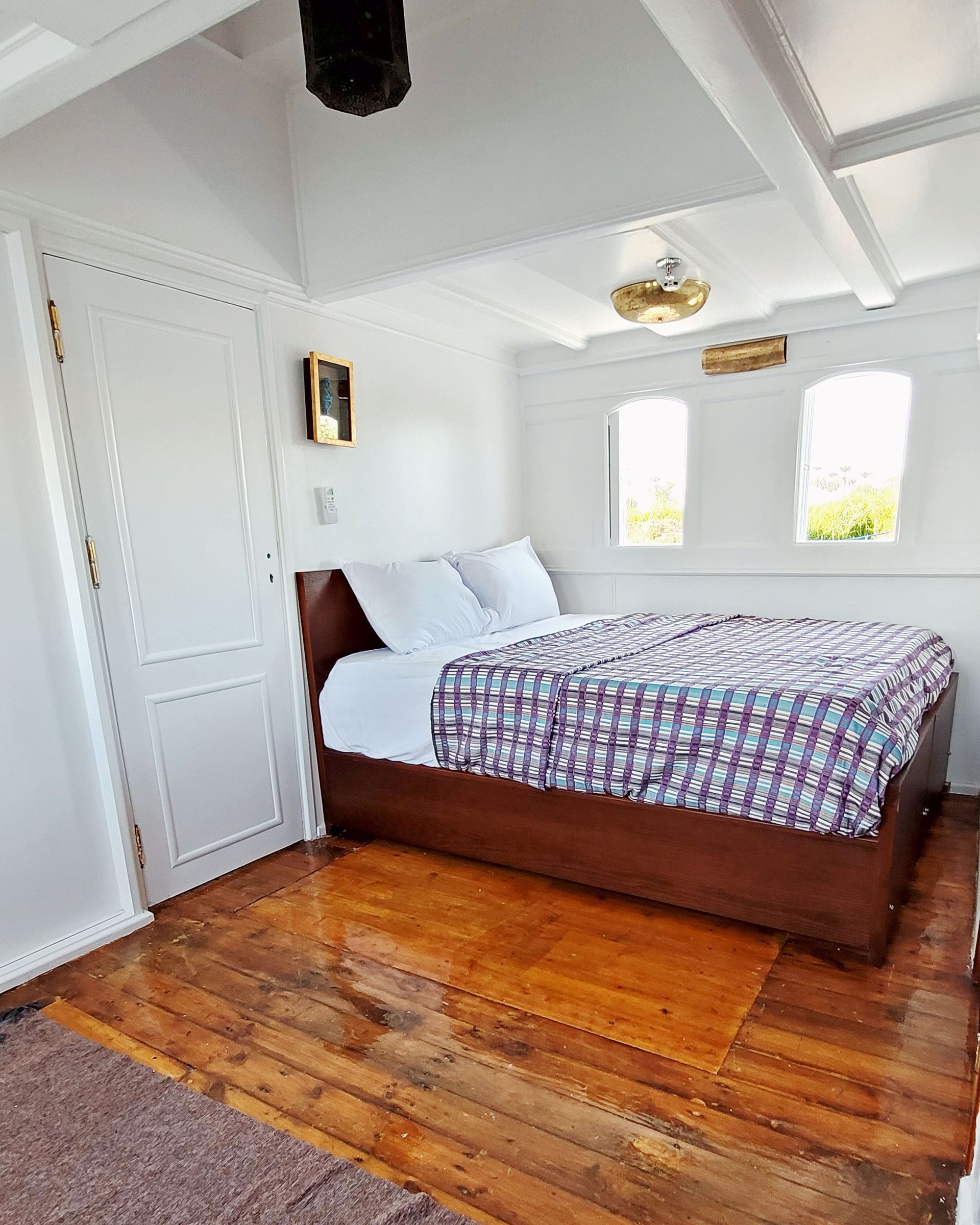 A picture of a cozy and elegant cabin/suite on the Dahabiya Kingfisher, a historic boat that offers exclusive Nile cruises between Luxor and Aswan. The Dahabiya Kingfisher is the original 1899 boat that was used by aristocrats and royalty to explore the Nile in style and comfort.