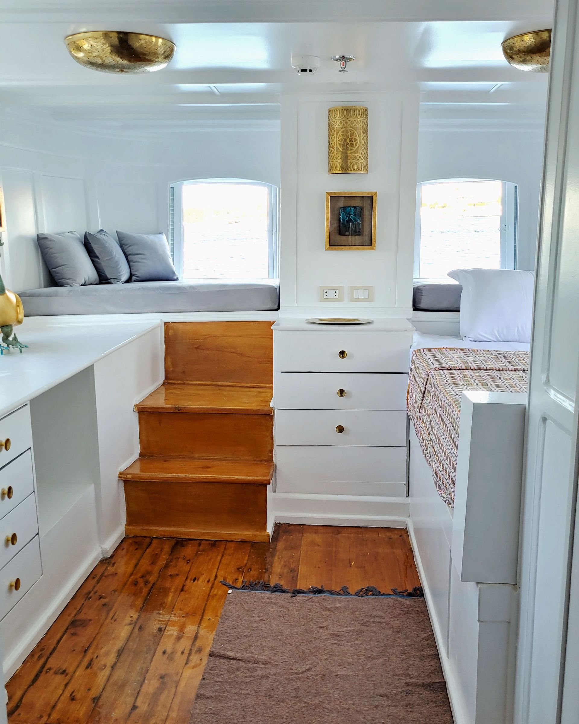 A picture of a cozy and elegant cabin/suite on the Dahabiya Kingfisher, a historic boat that offers exclusive Nile cruises between Luxor and Aswan. The Dahabiya Kingfisher is the original 1899 boat that was used by aristocrats and royalty to explore the Nile in style and comfort.