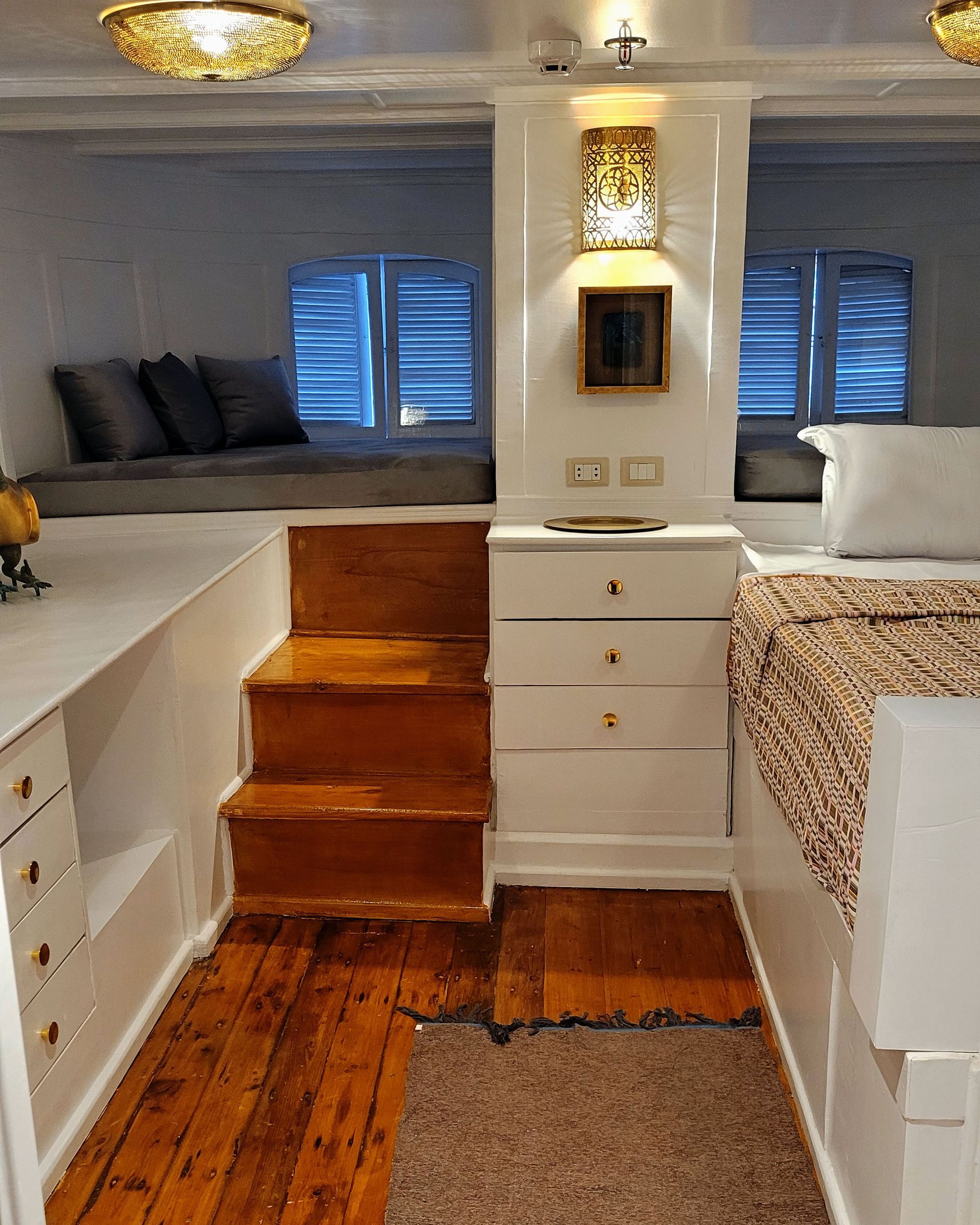 A picture of a cozy and elegant cabin/suite on the Dahabiya Kingfisher, a historic boat that offers exclusive Nile cruises between Luxor and Aswan. The Dahabiya Kingfisher is the original 1899 boat that was used by aristocrats and royalty to explore the Nile in style and comfort.