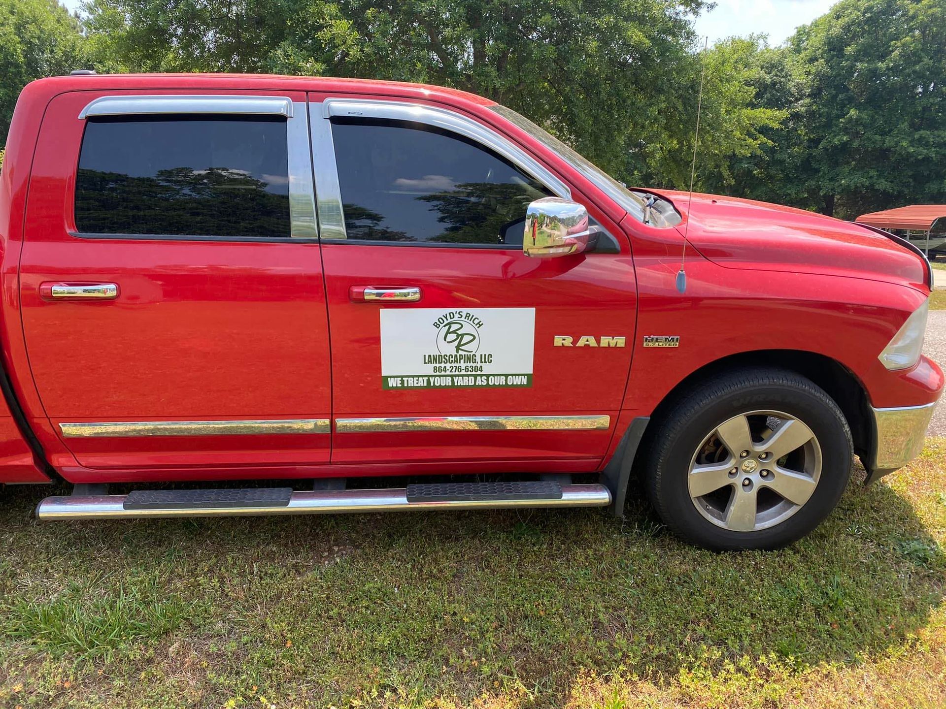 A red ram truck is parked in the grass.