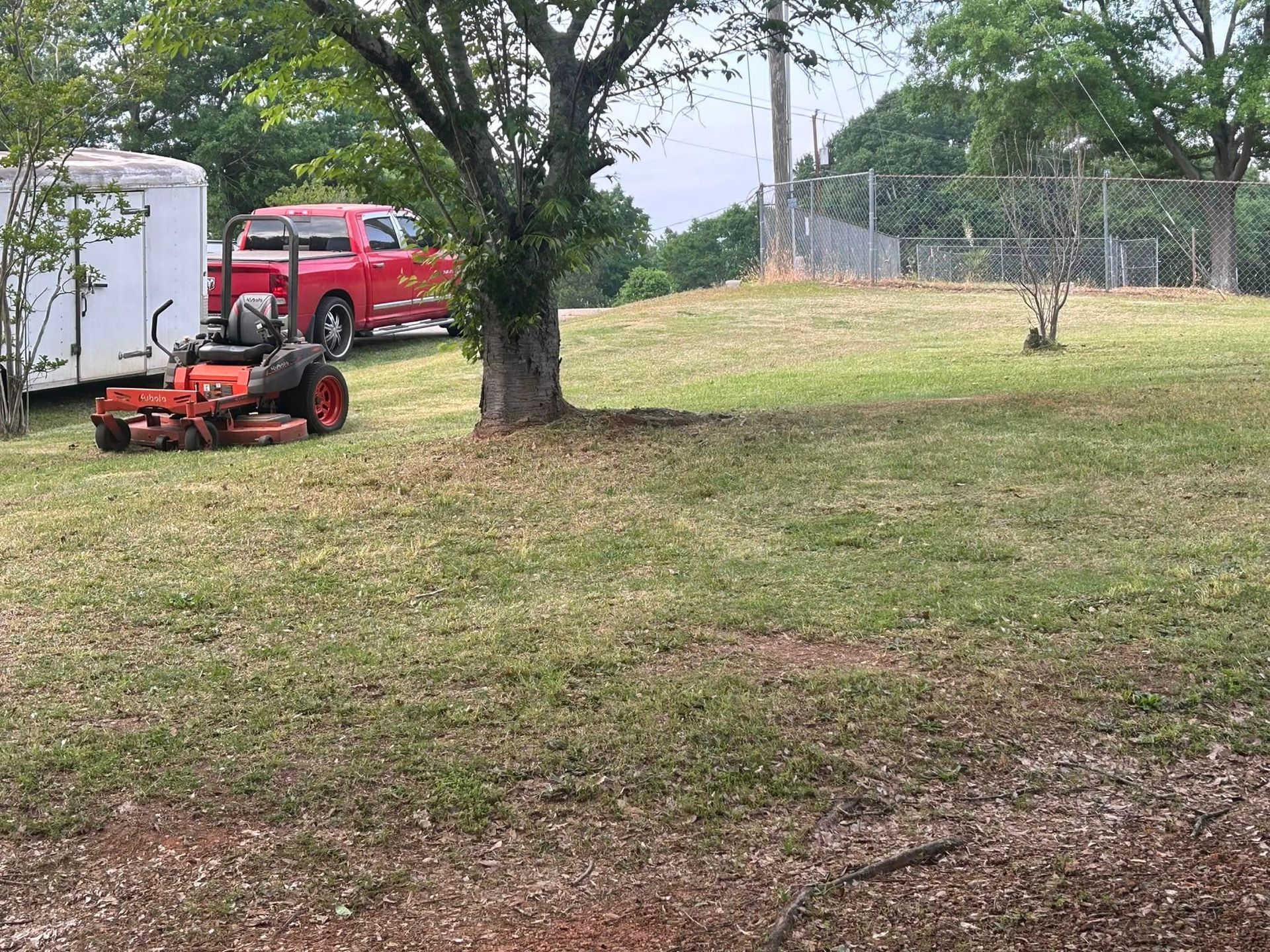 A lawn mower is sitting in the middle of a lush green field.