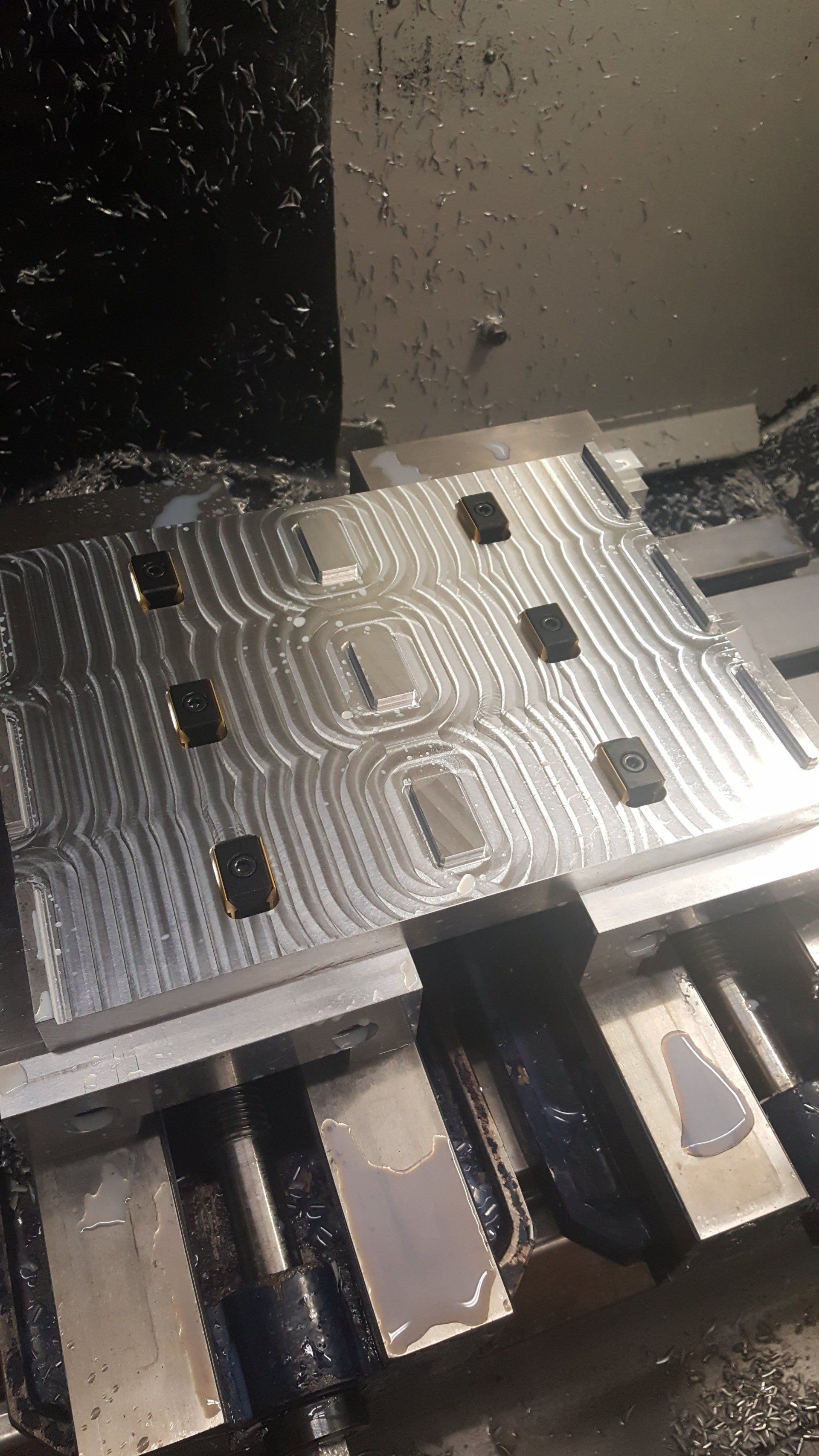 A machine is cutting a piece of metal on a table.