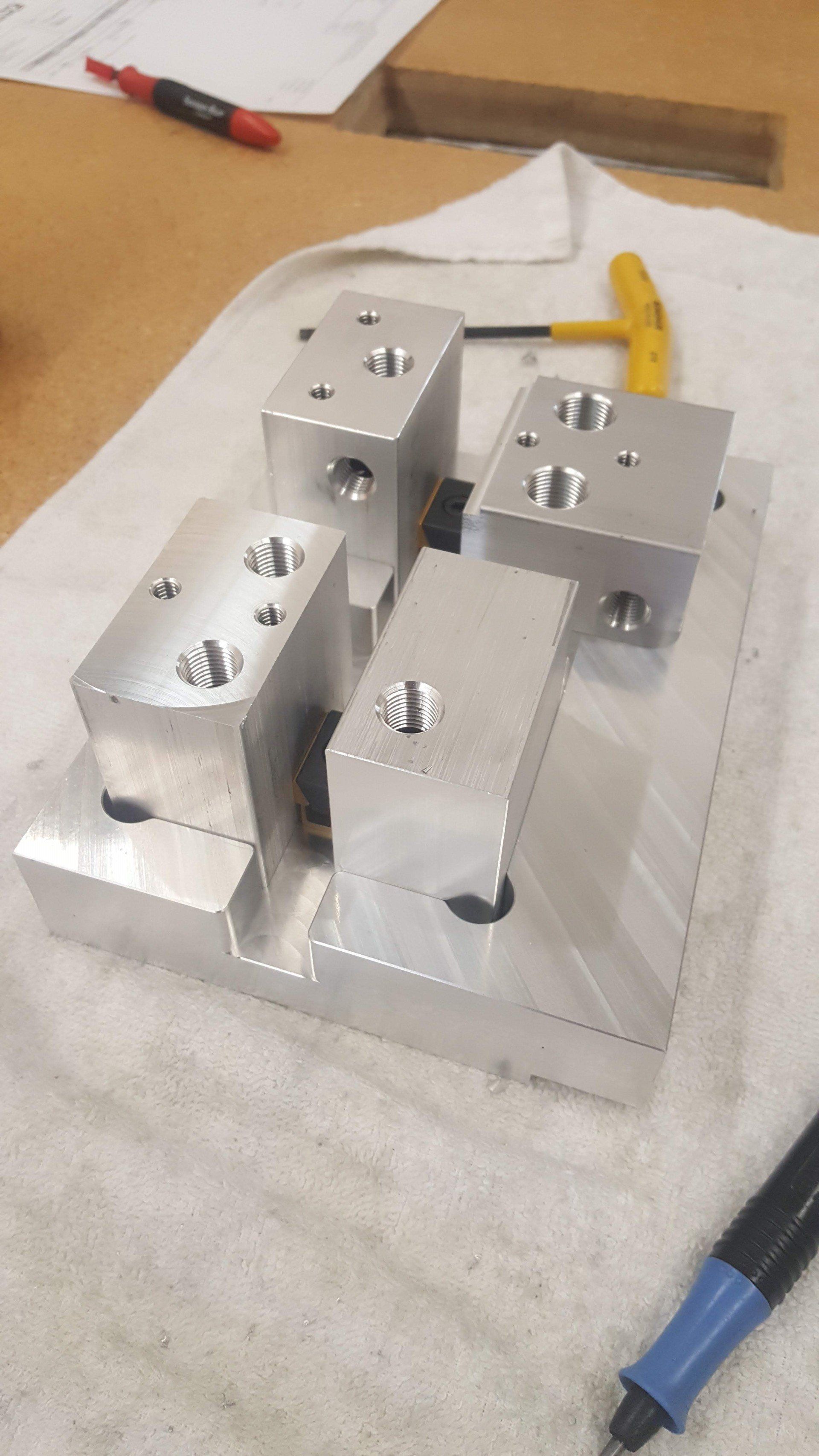 A piece of metal is sitting on a towel next to a pen.