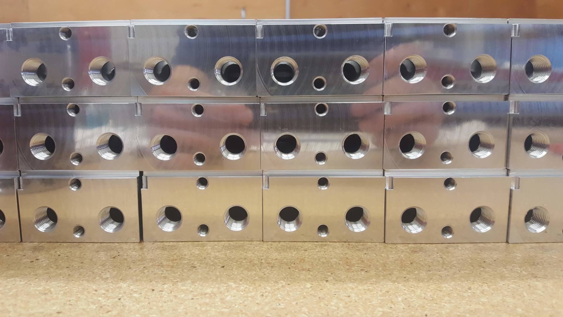 A row of metal blocks with holes in them are stacked on top of each other on a table.