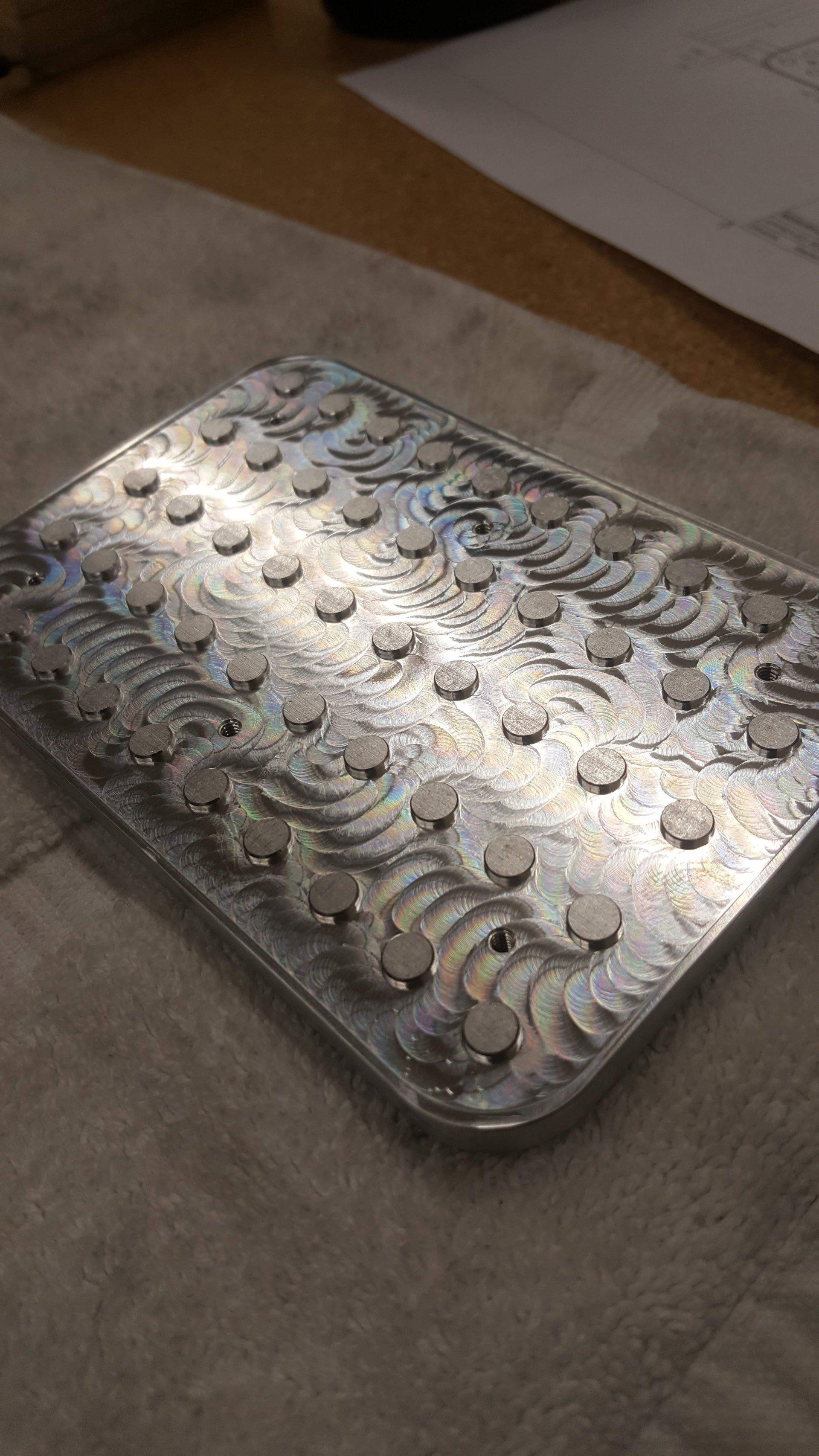A metal tray with coins on it is sitting on a table.