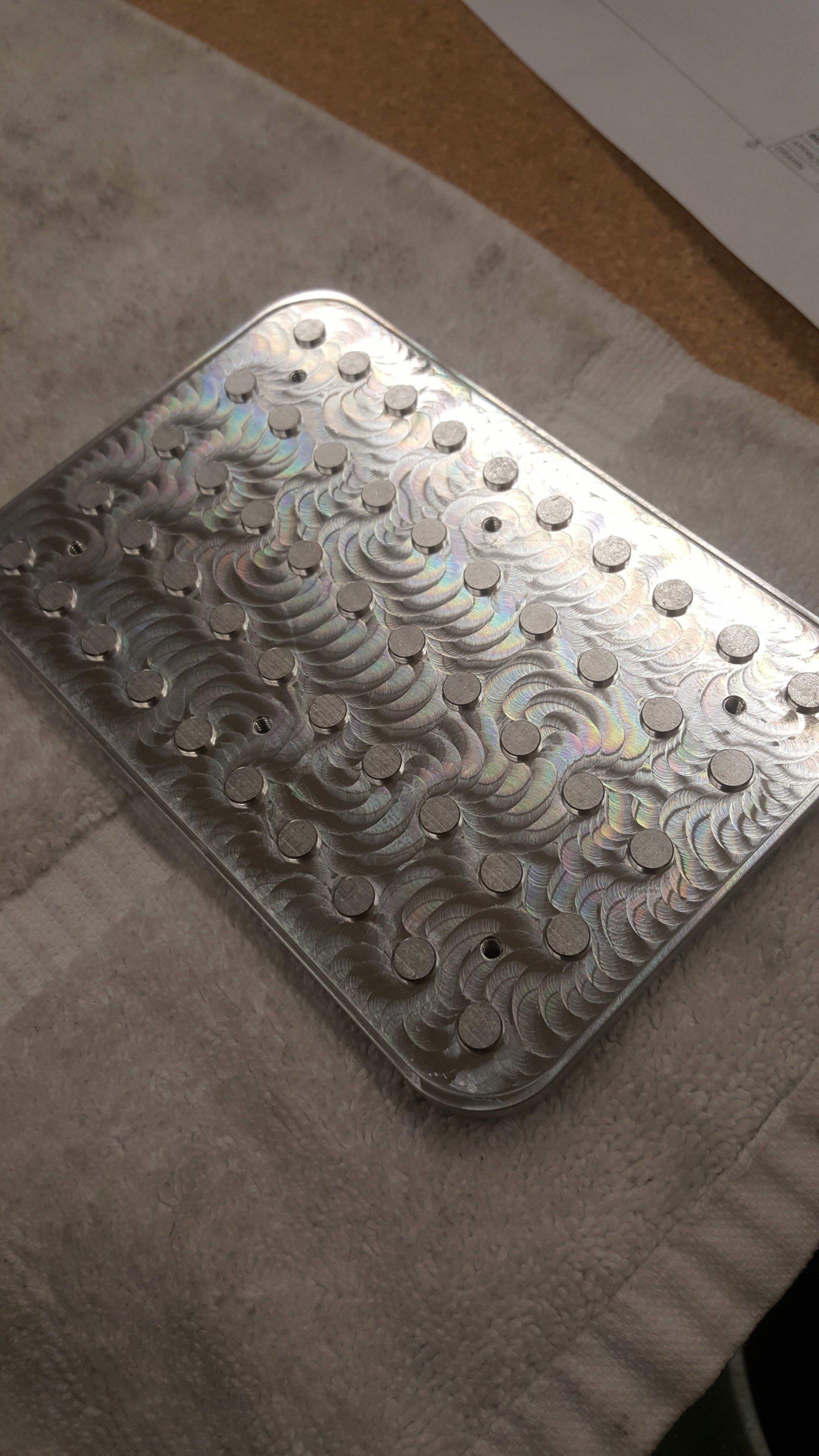 A silver plate with a pattern on it is sitting on a table.