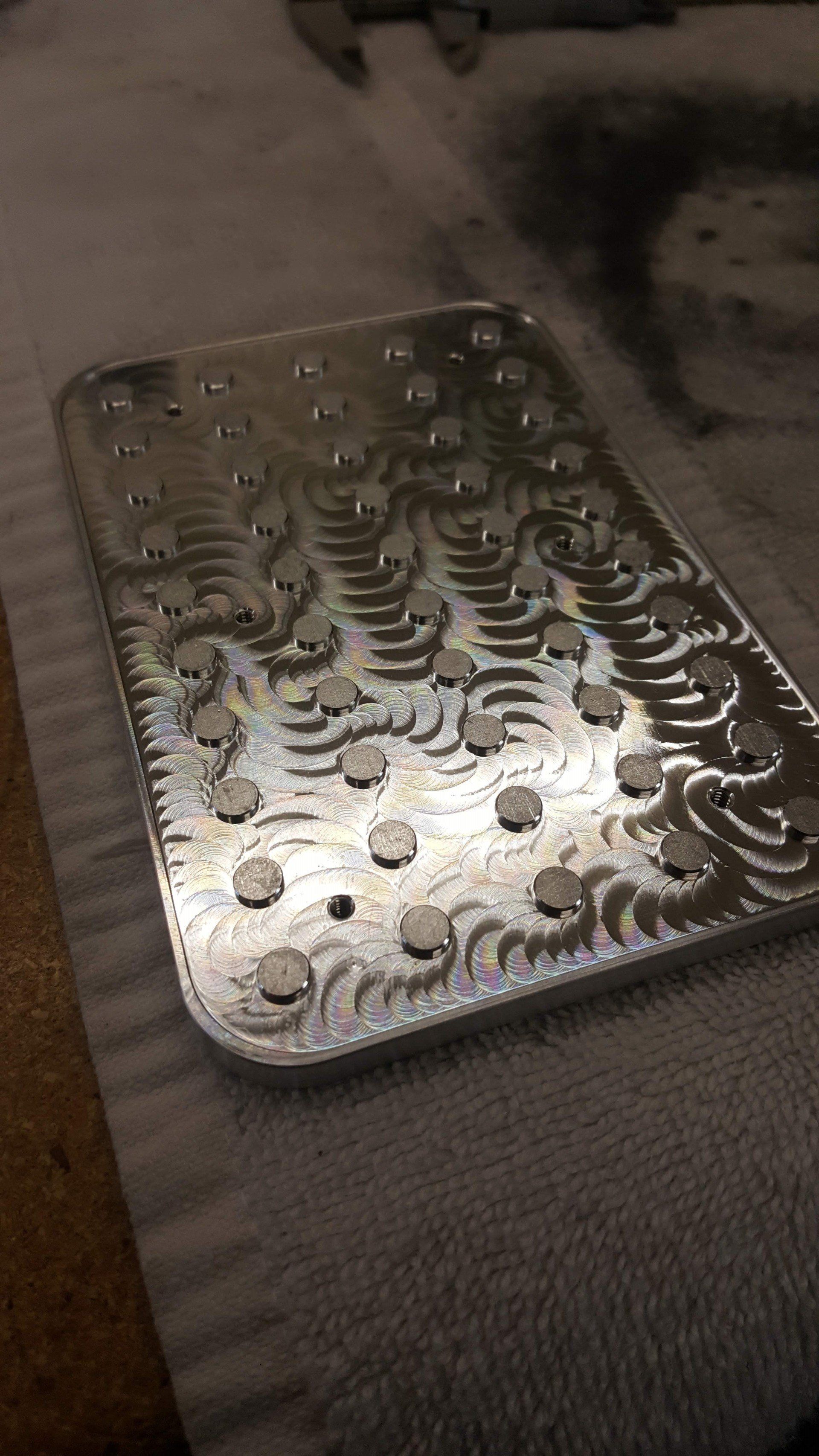 A metal tray with holes in it is sitting on a bed.